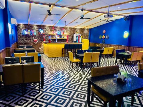 a restaurant with tables and chairs and a bar at Hotel Golden Fern in Patiāla