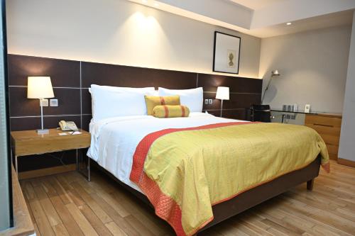 a hotel room with a large bed and a table at The LaLiT New Delhi in New Delhi