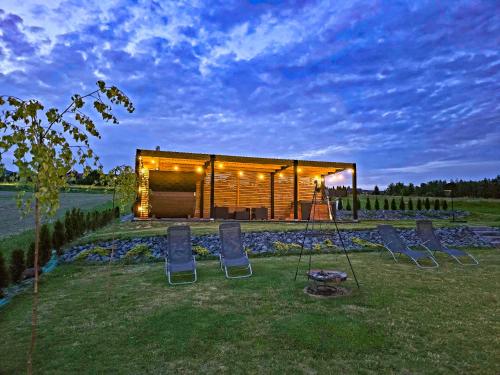 a house with a group of chairs in front of it at Domki Diabolina - sauna, jacuzzi, klimatyzacja, kominki in Krajno Pierwsze