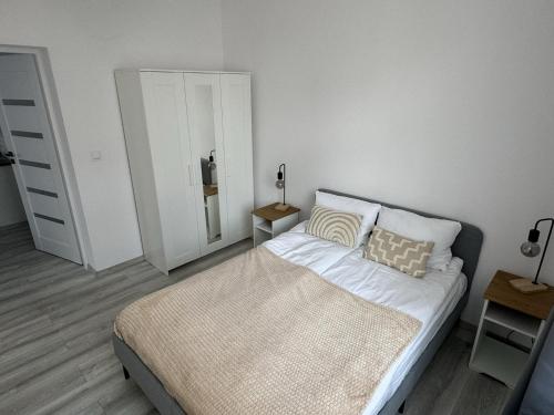 a bedroom with a large bed and a mirror at Apartamenty Przy Deptaku in Świnoujście