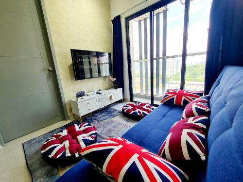 a living room with a blue couch with red and white pillows at Desa Park North Ikea One Utama ISP Damansara KL in Kuala Lumpur