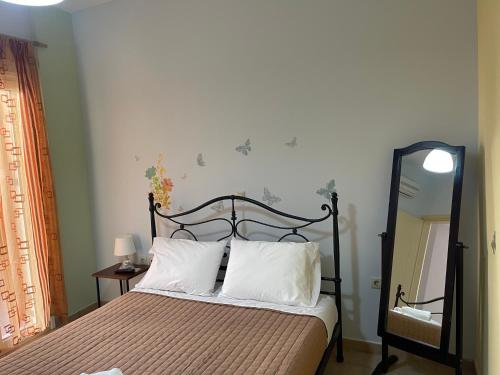 a bedroom with a bed and a mirror at 90sqm Perdika Aegina luxury family apartment με θέα βουνό και θάλασσα 90τμ in Perdhika