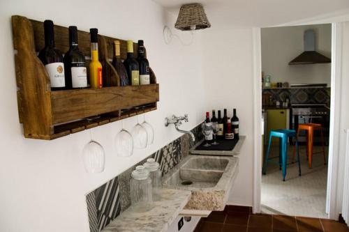 a kitchen with a sink and wine bottles on a wall at Guelio al Massimo Suites&Breakfast in Palermo