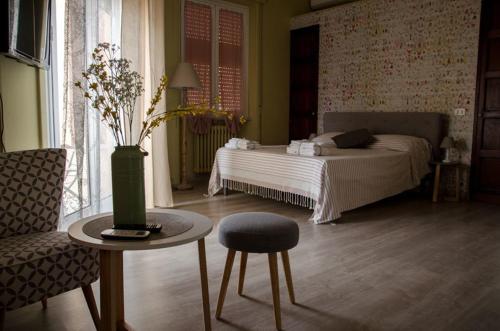 a bedroom with a bed and a table and a chair at Guelio al Massimo Suites&Breakfast in Palermo