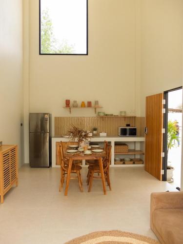 a kitchen with a table and chairs and a refrigerator at The Cabin88 Private pool villa in Ban Thung Ri