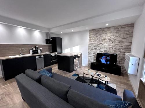 un salon avec un canapé bleu et une cuisine dans l'établissement Charme Manosquins, à Manosque