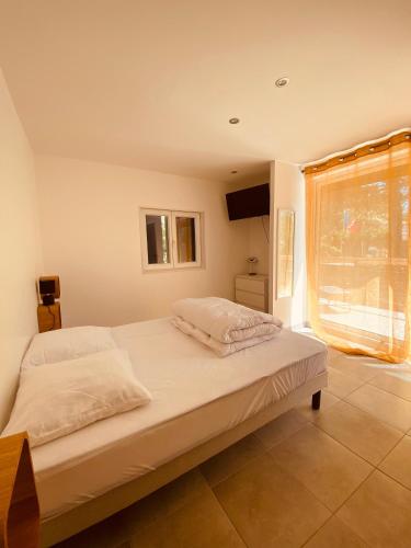 une chambre avec un grand lit blanc avec une fenêtre dans l'établissement Maison sur terrain spacieux 6 personnes proche des plages - RARE - V0826, à Vias