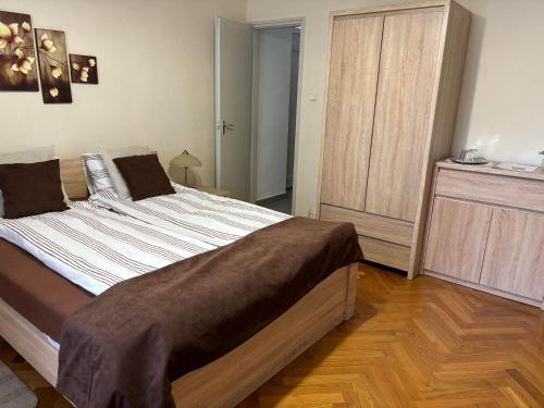 a bedroom with a large bed and a wooden floor at Szalay Villa in Veszprém