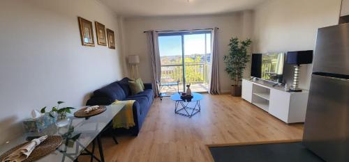 a living room with a blue couch and a television at One-Bedroom apartment in Goldsbrough Suites in Sydney