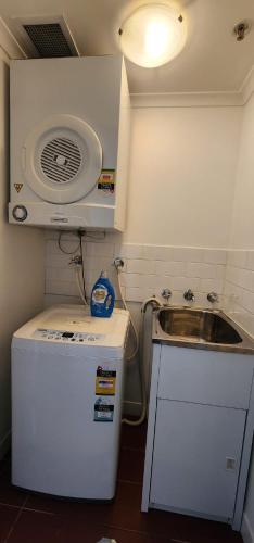 a small kitchen with a sink and a refrigerator at One-Bedroom apartment in Goldsbrough Suites in Sydney