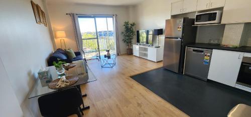 a kitchen and living room with a table and a refrigerator at One-Bedroom apartment in Goldsbrough Suites in Sydney