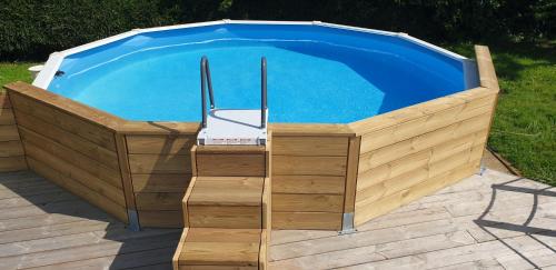 une piscine dans une boîte en bois à côté d'un dans l'établissement Maison au calme 6pers jardin, à Breuillet