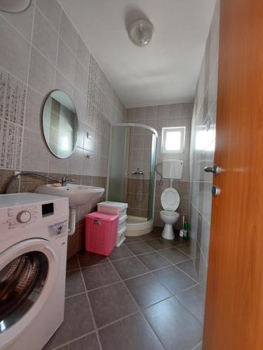 a bathroom with a washing machine and a sink at Vesna apartmani, Igalo in Igalo