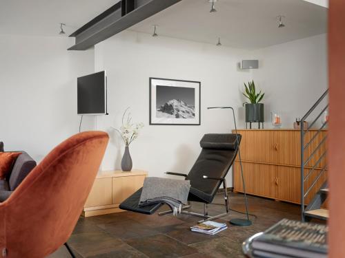 a living room with two chairs and a tv at Ascot Penthouse 160 m2 Matterhorn View in Zermatt