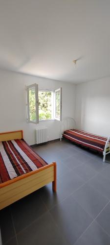 ein Zimmer mit zwei Betten und einem Fenster in der Unterkunft Maison de vacances in Saint-Clément-de-Rivière