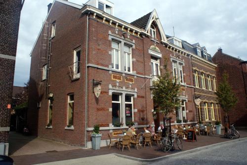 a brick building with tables and chairs in front of it at hotel le bonheur in Eijsden