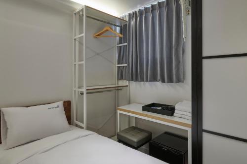 a small bedroom with a bed and a closet at Eight Rest Hostel Myeongdong in Seoul