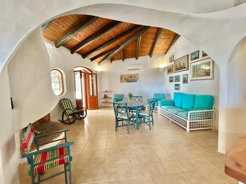 a living room with a blue couch and a table at Nura's - Villa Paola vista mare in La Ciaccia