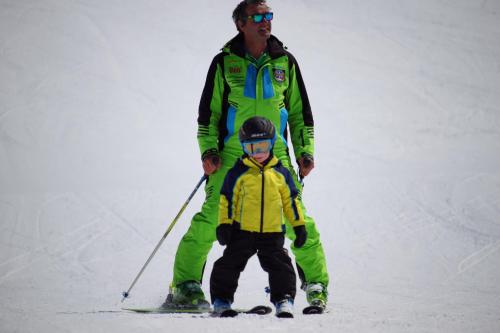 a man and a child on skis in the snow at Hotel Das Lisann in Pfelders