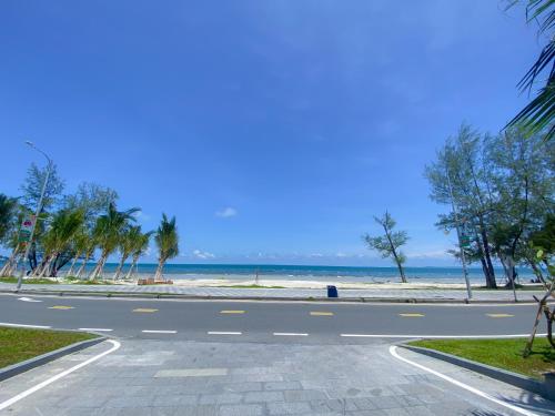 an empty road next to the beach with palm trees at DongHu Resort Hotel in Sihanoukville