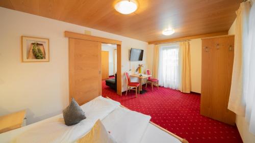 a hotel room with a bed and a table at Hotel Das Lisann in Pfelders
