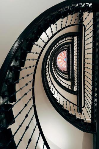 a spiral staircase in a building with a window at Adventure Hostel Madrid in Madrid