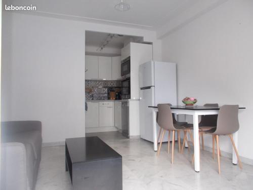 une cuisine et une salle à manger avec une table et des chaises dans l'établissement appartement nice proche mer, à Nice