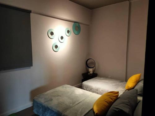 a bedroom with two beds and a wall with eyes on it at Cozy Loft oversee Penang Hill in Ayer Itam