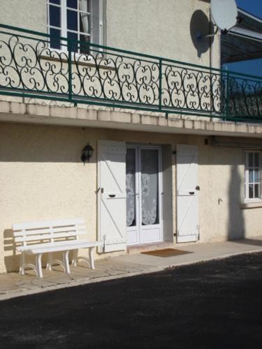 - un banc blanc devant un bâtiment avec balcon dans l'établissement Appartement indépendant au calme proche Périgueux, à Mensignac