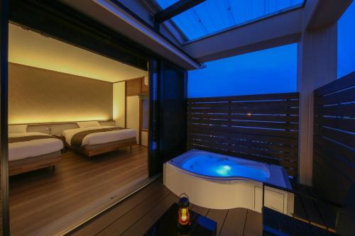 a hotel room with a jacuzzi tub in a bedroom at ROMANSTAY in Takayama