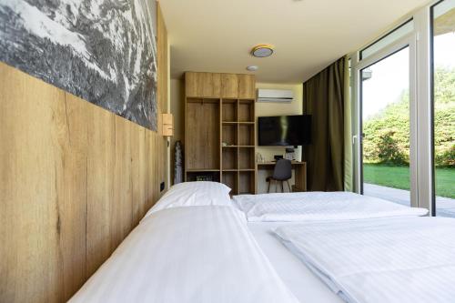 a bedroom with two beds and a window at Hotel Kranjska Gora in Kranjska Gora