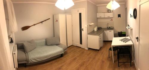 a living room with a couch and a kitchen at Apartamenty Ustka Pod Wiosłem in Ustka