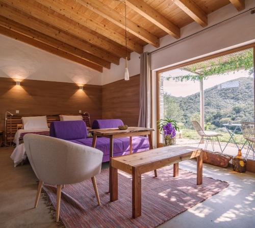 a living room with a table and purple chairs at Vale D Sancho Eco Turismo in Aljezur