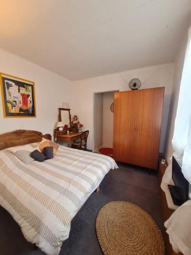 a bedroom with a bed and a wooden cabinet at La Gleyzinière 2 in Allevard