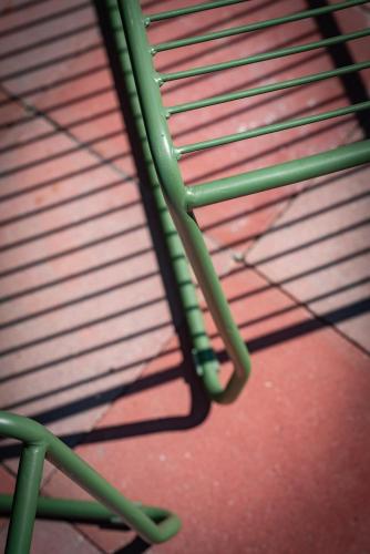 a green bench sitting on top of a red floor at ViaAmbioriX in Tongeren