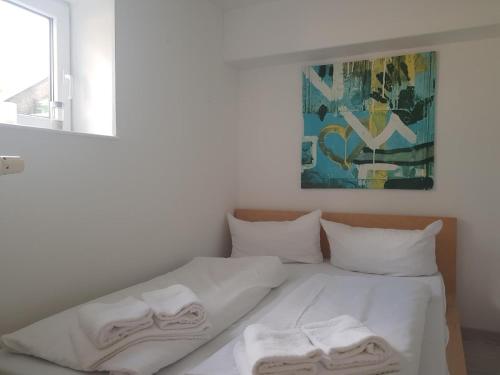 ein Bett mit weißen Laken und Handtüchern darauf in der Unterkunft Unterdeck in Wittdün