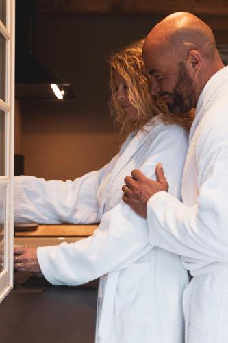 a man and a woman hugging each other at Paddock Lodge - Suites Wellness & Chambres d'hôtes in Stoumont