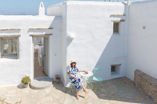 a woman in a blue dress sitting on a balcony of a white building at SUGAR CUBE Santa Maria in Santa Maria