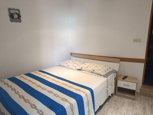 a bedroom with a bed with a blue and white blanket at Cozy room in Pula