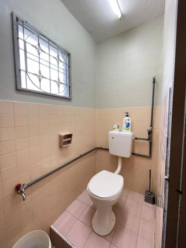 a bathroom with a white toilet and a window at 3 rooms Town Homestay 1 mins to Town in Teluk Intan