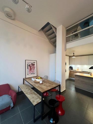 une cuisine et un salon avec une table et un canapé dans l'établissement Maison loft chez Karyn, à Nanterre