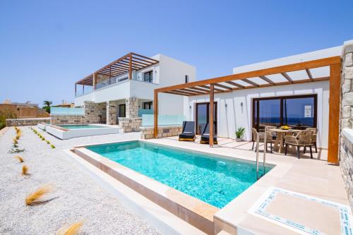 a villa with a swimming pool and a house at Elite Luxury Villas in Afiartis