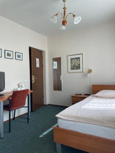 a hotel room with a bed and a desk and a television at Livonija in Sigulda