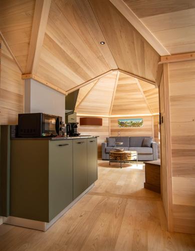 an open kitchen and living room with a couch at Les Kotas du bonheur in Soultzeren