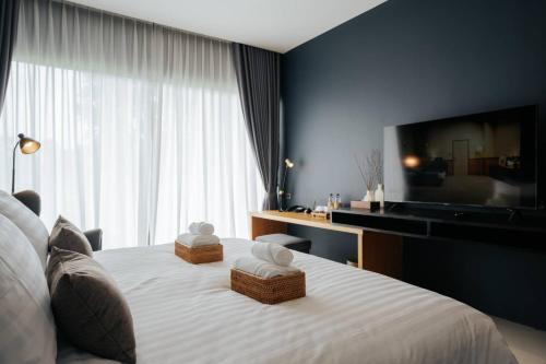 a bedroom with a white bed with a large window at The Grandiose Hotel Chiang Rai เดอะแกรนด์ดิโอสเชียงราย in Chiang Rai