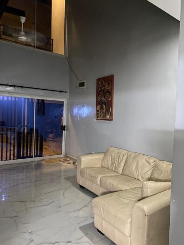 a living room with a white couch and a window at New modern apartment in Bijilo in Bijilo