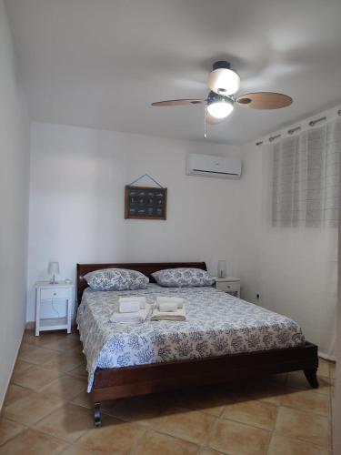 a bedroom with a bed and a ceiling fan at Appartamenti Za Barbara in Lampedusa