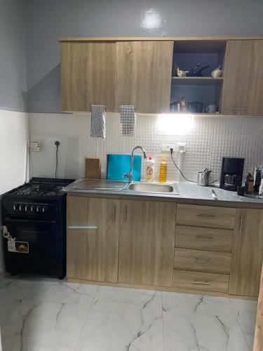a kitchen with a sink and a stove at New modern apartment in Bijilo in Bijilo