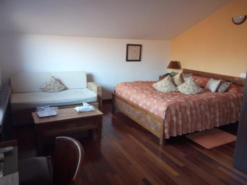 a hotel room with a bed and a table at Resort Bali Spa in Cornu de Jos