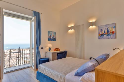 a bedroom with a bed and a view of the ocean at Amunì - Exclusive Suite in Centro a Cefalù Vista Mare by CEFALU BIZ in Cefalù